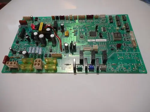 Druckplatine mit elektronischen Bauteilen, darunter Widerstände, Kondensatoren und Schalter, für eine Außeneinheit von Remeha.